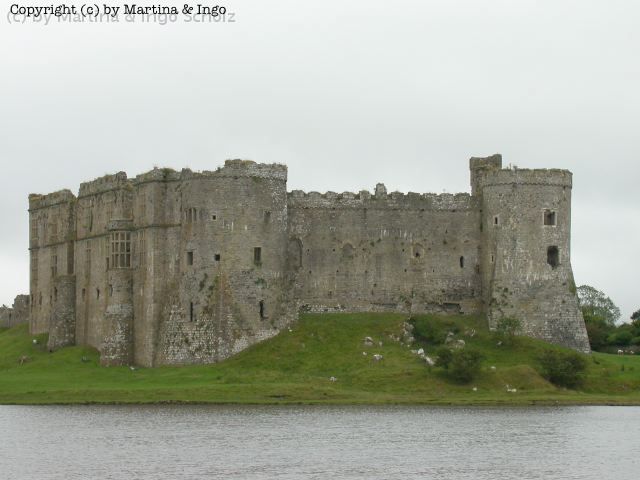 dscn0148.jpg - Carew Castle liegt direkt gegen�ber einer der wenigen Gezeitenm�hlen, die ihre M�hlsteine durch das Stauen und Ablassen des Flutbeckens, im Vordergrund zu sehen, in Bewegung setzt. Vor dem Schlo� befindet sich ein High-Cross, dass als Wahrzeichen f�r kulturelle Sehensw�rdigkeiten dient.